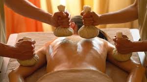 Pottali Massage - A person receiving a herbal pouch massage